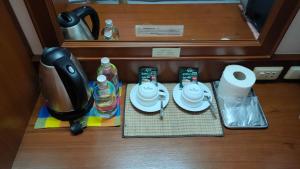a table with dishes and bottles of water in a suitcase at Thepparat Lodge Krabi in Krabi town