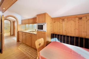 een keuken met houten kasten en een magnetron bij Casa Li Roina n 44 in Livigno