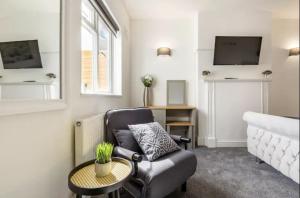 a living room with a chair and a table at Luxury 3-Bed Apartment Near To London With Parking in Hornchurch