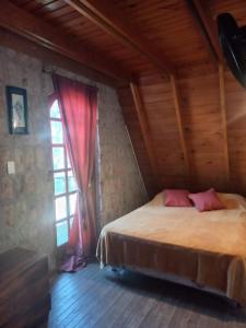 1 dormitorio con 1 cama y ventana en una habitación en Casa Alpina espaciosa a 2 cuadras del centro de Villa Gesell y a 5 de la playa en Villa Gesell