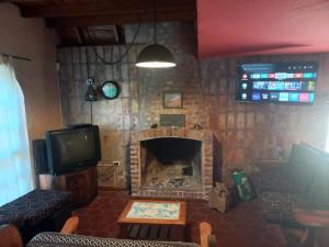 sala de estar con chimenea y TV en Casa Alpina espaciosa a 2 cuadras del centro de Villa Gesell y a 5 de la playa en Villa Gesell