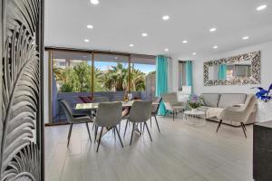 a dining room and living room with a table and chairs at LAS AMERICAS BEACH, 2 Bedrooms, Fiber, Pool in Playa de las Americas