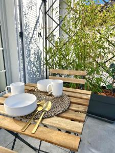 Una mesa de madera con platos y utensilios sobre ella. en Le Cocon - Coeur de ville, en La Rochelle 3 fotos más