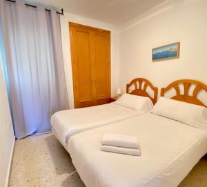 two beds sitting next to each other in a bedroom at Aptos La Costera in Benidorm