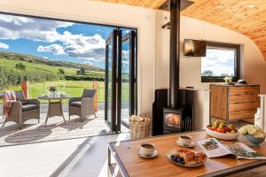 a living room with a fireplace and a patio at Little Heaning in Cartmel