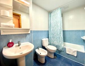 a bathroom with a sink and a toilet and a mirror at Aptos La Costera in Benidorm