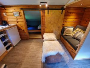 ein kleines Wohnzimmer mit einem Sofa und einem Kühlschrank in der Unterkunft Scandinavisch dorp in Eelderwolde