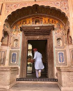 a person standing in a doorway of a building at Mandawa Kothi in Mandāwa