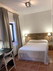 1 dormitorio con 1 cama blanca grande y escritorio en Cortijo Los Lomillos - La Encina, 