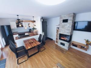 a living room with a table and a fireplace at Apartma M&J in Mojstrana