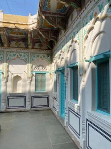 a building with an ornate ceiling and a corridor at Mandawa Kothi in Mandāwa