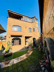 una gran casa de ladrillo con un patio de hierba en Ma Petite Maison, en Tepoztlán