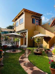 a house with an outdoor patio with tables and umbrellas at Ma Petite Maison in Tepoztlán