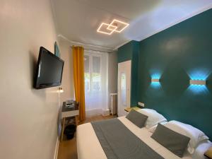 a bedroom with a bed and a tv on a wall at Lyo Hôtel - Centre Lyon Perrache in Lyon