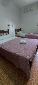1 dormitorio con 2 camas y edredón morado en Hotel Central en Buenos Aires
