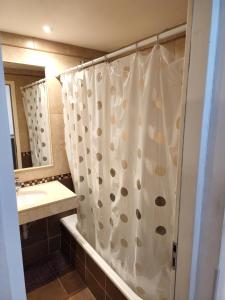 y baño con cortina de ducha y lavamanos. en Fantástico departamento, en la mejor ubicación. en Salta