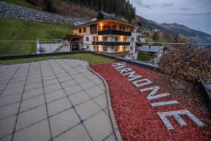 a house on a hill with a garden with red flowers at Apart Harmonie in Kappl