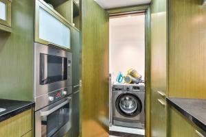 cocina con lavadora y microondas en Lofts · Downtown Luxury · 5 Min Walk To Dubai Fountain!, en Dubái