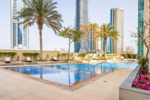uma piscina com palmeiras e edifícios em Lofts · Downtown Luxury · 5 Min Walk To Dubai Fountain! no Dubai