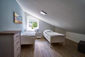 a attic bedroom with two beds and a window at FeWo Am Markt in Seedorf
