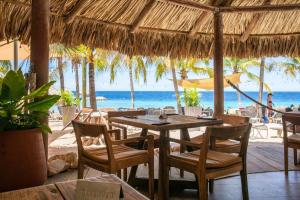 - un restaurant avec une table et des chaises sur la plage dans l'établissement Blue Bay Beach Apartments, à Blue Bay