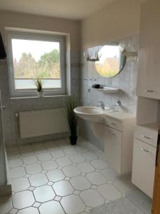 a white bathroom with a sink and a window at Ferienhaus Annu in Lensahn