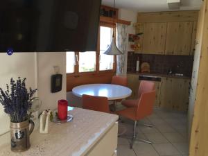 a kitchen with a table and chairs in a kitchen at Ferienwohnung im Haus Primula in Obersaxen