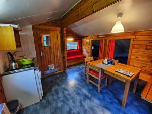 a kitchen and dining room with a table and a refrigerator at Scandinavisch dorp in Eelderwolde