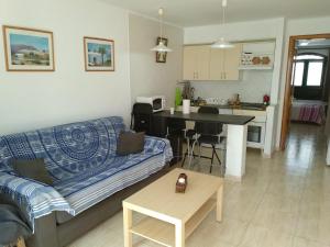 uma sala de estar com um sofá e uma cozinha em CASA MERY em Puerto del Carmen