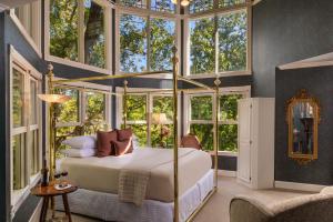 a bedroom with a canopy bed with windows at Arsenic and Old Lace Bed & Breakfast Inn in Eureka Springs