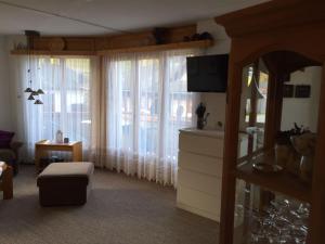 a living room with a large window with curtains at Ferienwohnung im Haus Primula in Obersaxen