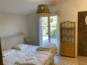 1 dormitorio con 2 camas y ventana en Lovely "Provence" villa with sea view, private heated pool, airco and beautiful garden en Grimaud