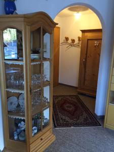 a wooden cabinet with glasses in it in a room at Ferienwohnung im Haus Primula in Obersaxen