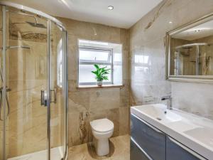 a bathroom with a toilet and a shower and a sink at Beechfield in Harrogate