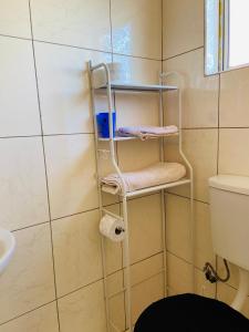 a towel rack in a bathroom with a toilet at Village Retreat Ngcamngeni in Debe Nek