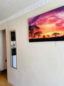 a painting of a sunset on a wall at Village Retreat Ngcamngeni in Debe Nek