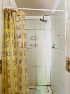 a shower with a yellow curtain in a bathroom at Village Retreat Ngcamngeni in Debe Nek