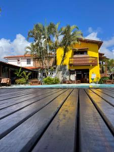 a wooden deck in front of a house at Pousada das Gaivotas in Guaibim