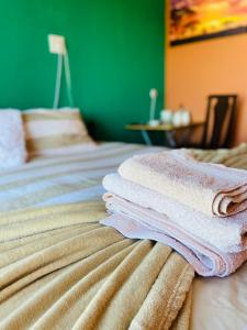 a stack of towels sitting on top of a bed at Village Retreat Ngcamngeni in Debe Nek
