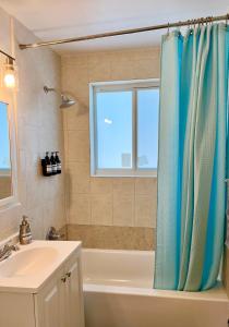 La salle de bains est pourvue d'une baignoire, d'un lavabo et d'une fenêtre. dans l'établissement Enchanting cozy Apartment 10 min away from airport, Calle 8, Brickell, Coral Gables, the beach and more!, à Miami