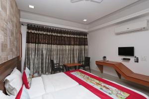 a hotel room with a bed and a desk at OYO Hotel Grand Nishat in Patna