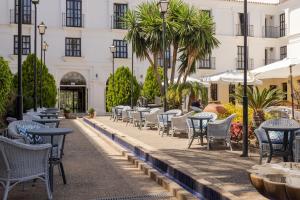 a row of tables and chairs in front of a building at Ilunion Hacienda de Mijas in Mijas