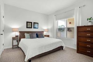 a white bedroom with a bed and a window at Minutes2Beaches in Destin