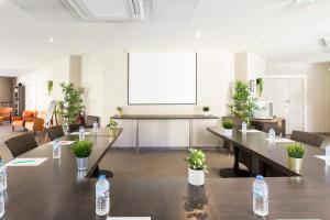 - une salle de réunion avec des tables et des bouteilles d'eau dans l'établissement Garden & City Aix En Provence - Rousset, à Rousset