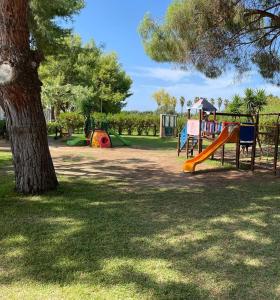 een speeltuin met een glijbaan naast een boom bij Resort Sciabache in Zambrone