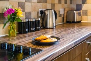 a counter top with a plate of pastries and flowers at Goodramgate Apartments in York