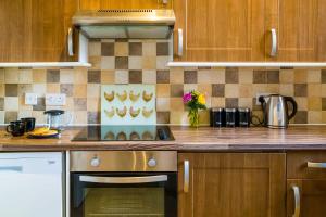 cocina con armarios de madera y horno con fogones en Goodramgate Apartments, en York