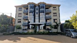 坎帕拉Eric Wilkins Apartments的一栋建筑前停着一辆车