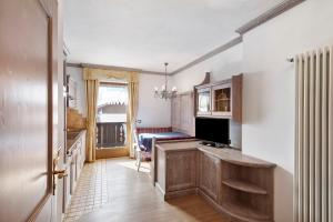 kuchnia z drewnianymi szafkami i stołem z kuchenką mikrofalową w obiekcie Casa Li Roina n 47 w Livigno
