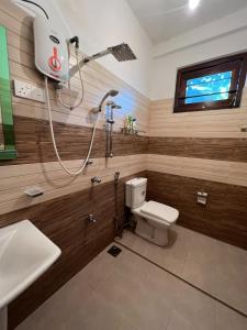 a bathroom with a shower and a toilet and a sink at Plantation Inn in Weligama